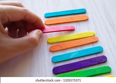 Hand Holding A Red Popsicle Stick During Process Of Making The Art . The Stick Is Widely Used As Crafting Supplies