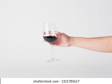 Hand Holding Red Wine Glass On A White Background.