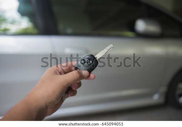 Hand\
holding  remote car for lock  and unlock the\
door.