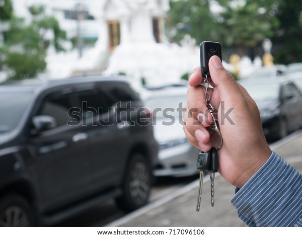 Hand\
holding remote car for lock and unlock the\
door.