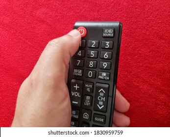 Hand Holding A Remote Control And Ready To Press The Turn Off Button 