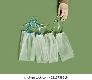 Hand Holding Reusable Grocery Bags From Net, Reusable Packaging For Fruits And Vegetables, Set Eco Mesh Bag With Colored Ribbon Ties, Eco Friendly And Zero Waste Concept, Minimal Style, Top View