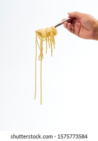 Hand Holding Roll Pasta Spaghetti With A Fork On White Background. Space For Text.