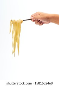 Hand Holding Roll Pasta Spaghetti With A Fork On White Background. Space For Text.