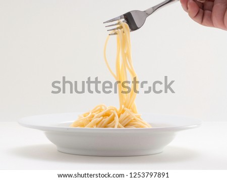 hand holding roll pasta spaghetti with a fork and bish on white background