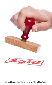 Hand Holding A Rubber Stamp With The Word Sold