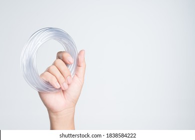 Hand Holding Rubber Tubing For Medical Or Liquid Transfer In Fish Tank On White Background