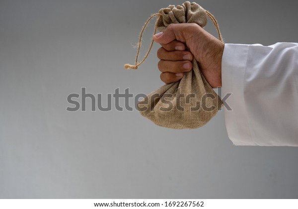 Hand holding sack of coin with copy space . bailout\
concept  