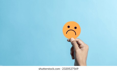 Hand holding sad face negative emotion. emotional intelligence, balance emotion control, mental health assessment, bipolar and depression, mental health concept, personality, therapy healing split. - Shutterstock ID 2320527569