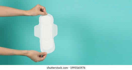 Hand is holding Sanitary napkin  ongreen mint or tiffany blue background. - Shutterstock ID 1995565976