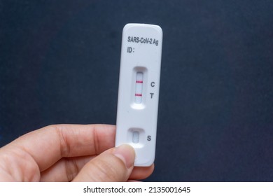 Hand holding the SARS CoV-2 virus rapid test kit with possitive results. Antigen covid test