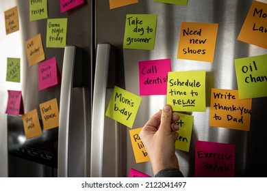 Hand Holding Schedule Time to Relax Sticky Note Memo to Fridge Door Full of Colorful Reminders - Powered by Shutterstock