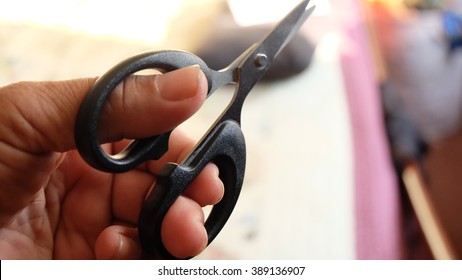 Hand holding the scissors