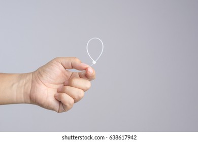 Hand holding self lock plastic cable on white background