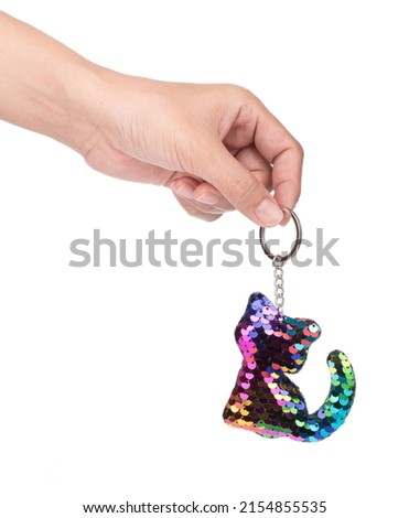Hand holding Sequin Cat Cute Keychain isolated on white background.