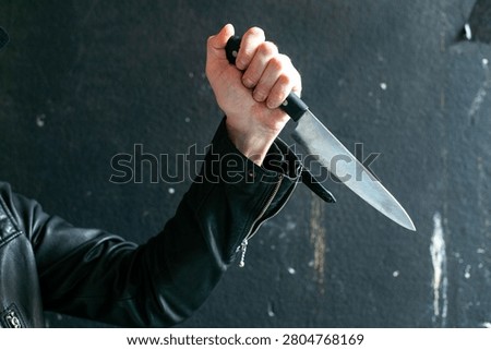 Hand holding sharp knife menacingly.