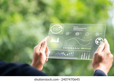 Hand holding and showing transparent tablet device. Business, natural green bokeh background,technology concept,alternative energy,conservative clean energy,ESG concept,Carbon credit,Carbon neutral. - Powered by Shutterstock