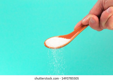 Hand Holding A Silver Spoon With Sugar 