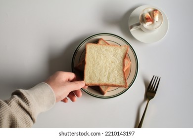 Hand Holding Slice Bread And Cup Of Coffee With Marshmallow On White Background. Morning Breakfast, Coffee Break. Tasty Beverage And Sweet Bakery. Winter And Autumn Concept