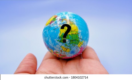 Hand holding small globe with question mark symbol. Business concept of future connectivity trends, how does connectivity in globalized world during the financial crisis due to coronavirus impact. - Powered by Shutterstock - Get 15% off with code: PIKWIZARD15