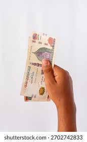 Hand holding a small stack of Egyptian 200 Pound banknotes vertically against a white background, perfect for concepts of payment, business, and financial transactions