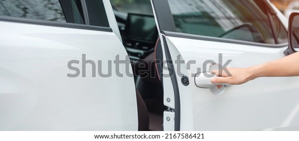 Hand holding smart car\
handle and opening a door. Transport, travel, service and car\
rental concept