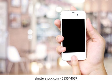 Hand Holding Smart Phone Over Blur Restaurant Background, Restaurant Reservation, Food Online, Food Delivery Concept