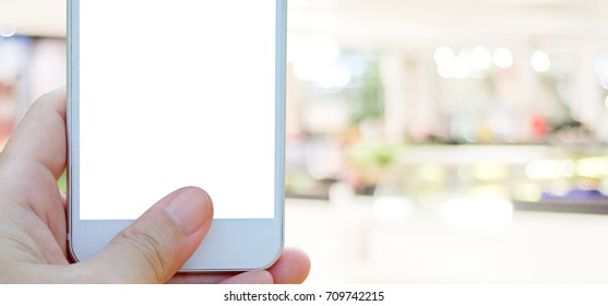 Hand holding smart phone over blur store background, banner, e-commerce, digitalmarketing, business and technology concept