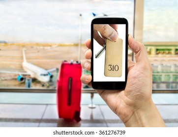 Hand Holding A Smart Phone With A Picture Of Hand Holding The Key Of Hotel At The Airport Lounge