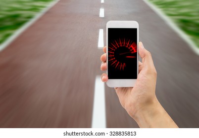 Hand Holding The Smart Phone With Tachometer Speed In The Screen Over The Road In Background