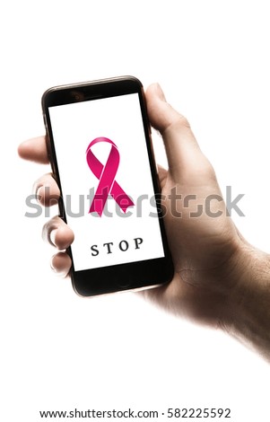 Hand holding smartphone, blank screen with pink ribbon isolated on white background. World Cancer Day graphic. Breast cancer concept