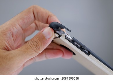 Hand Holding Smartphone With Broken Smartphone Case Plain Background. Cracking Smartphone Case. Damaged Phone Case.