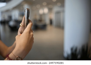 A hand is holding a smartphone, capturing beautiful memories during a lively gathering filled with people - Powered by Shutterstock