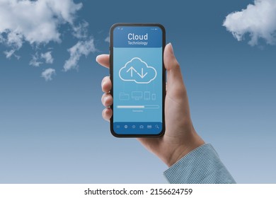 Hand holding a smartphone and cloud-based application, the user is downloading data on the device, POV shot