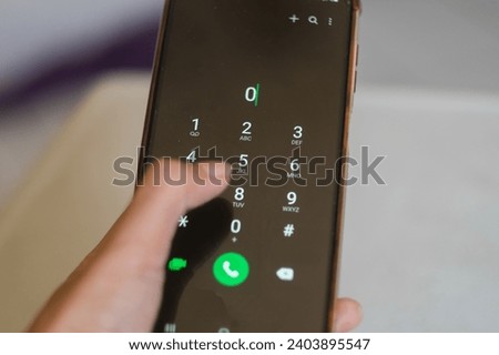 Hand holding smartphone device and touching screen. Closeup of female hand holding cell phone dialing a phone number 