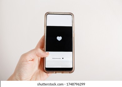 Hand Holding Smartphone And Giving Like On Black Square In Social Media. Person Support Activist USA Movement Black Lives Matter Online. People Protest Against Racism. Blackout Tuesday 2020.