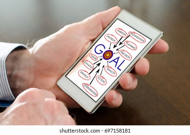 Hand holding a smartphone with goal concept