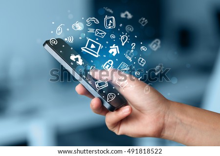 Hand holding smartphone with media icons and symbol collection