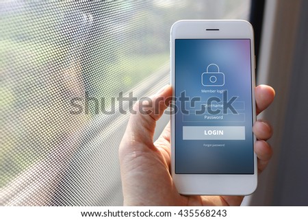 Hand holding smartphone with member loging screen on train window background