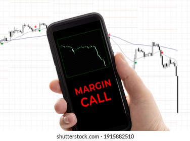 Hand holding a smartphone with the message margin call. Trading loss stock exchange. Brokerage account - Shutterstock ID 1915882510