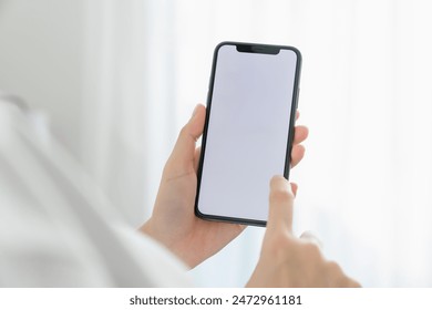 Hand holding smartphone mockup of blank screen for graphic display montage. - Powered by Shutterstock