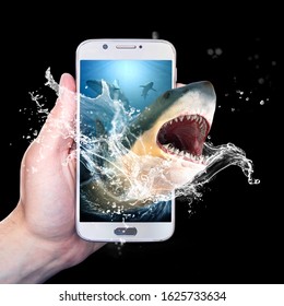 Hand Holding A Smartphone With A Shark Coming Out Of It. Isolated On Black Background.