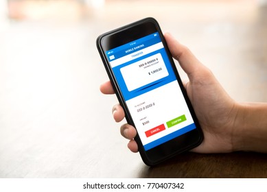 Hand holding smartphone showing amount of money will be transferred online via electronic internet banking application - financial technology or fintech concept - Shutterstock ID 770407342