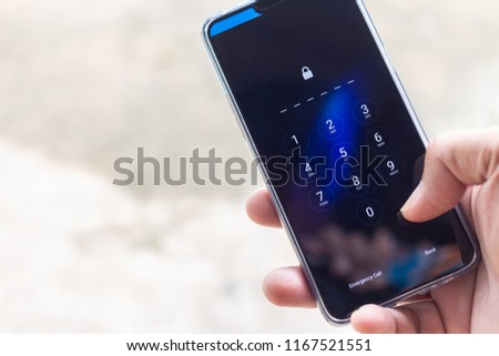 Hand holding smartphone while entering the passcode.