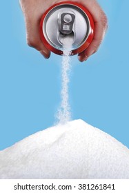 Hand Holding Soda Can Pouring A Crazy Amount Of Sugar In Metaphor Of Sugar Content Of A Refresh Drink Isolated On Blue Background In Healthy Nutrition, Diet And Sweet Addiction Concept