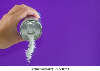 Hand Holding Soda Can Pouring A Crazy Amount Of Sugar In Metaphor Of Sugar Content Of A Refresh Drink Isolated On Purple Background In Healthy Nutrition, Diet And Sweet Addiction Concept