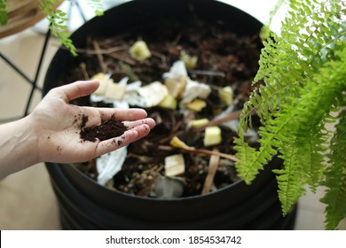 Hand Holding Soil Over Indoor Wormery Compost Bin