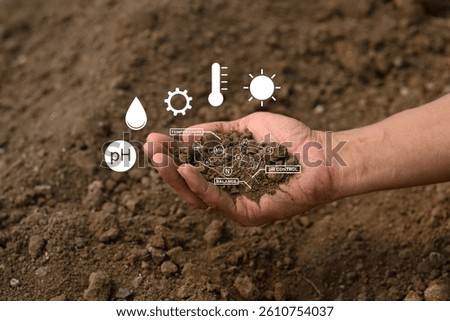 Hand holding soil with virtual interface displaying crucial data on nutrients, temperature, pH and moisture