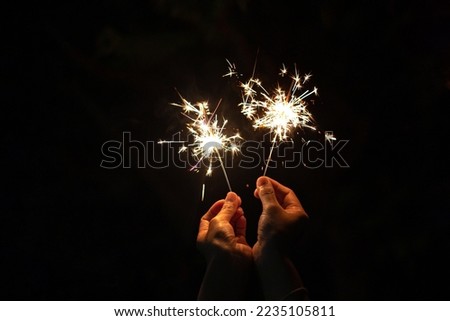 hand holding sparkler isolated on black background symbolizes the new year and celebration