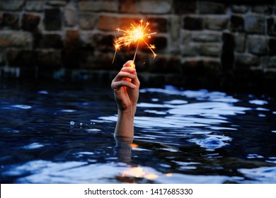 Hand holding sparkler in water at dusk for july 4th concept. - Powered by Shutterstock